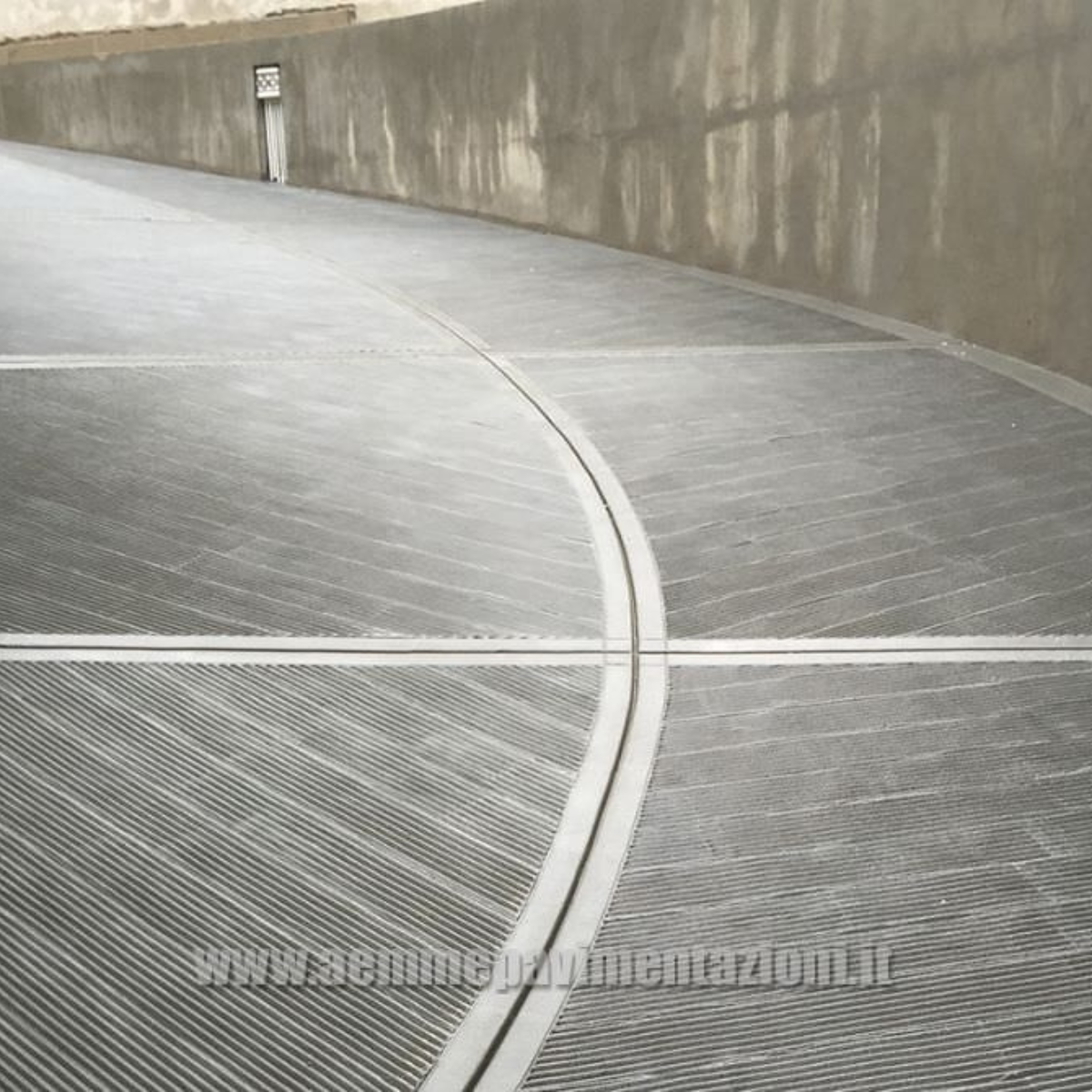 Rampa in calcestruzzo con finitura a lisca di pesce